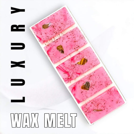 Pink coloured Cranberry wax melt with Tigers eye crystals on white background with the words Luxury Wax Melt