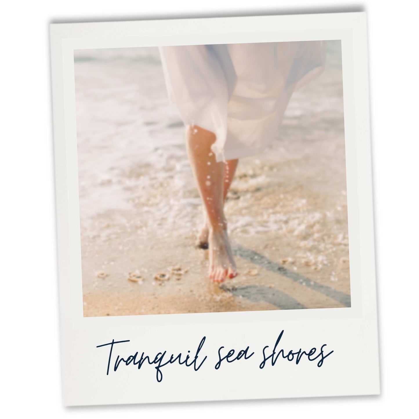 a human in white robe walking along the shoreline of a sandy beach