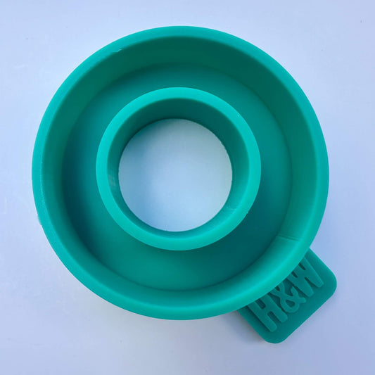 A teal green silicone Halo ring disc car freshie mould photographed from a top-down perspective on a light blue background.