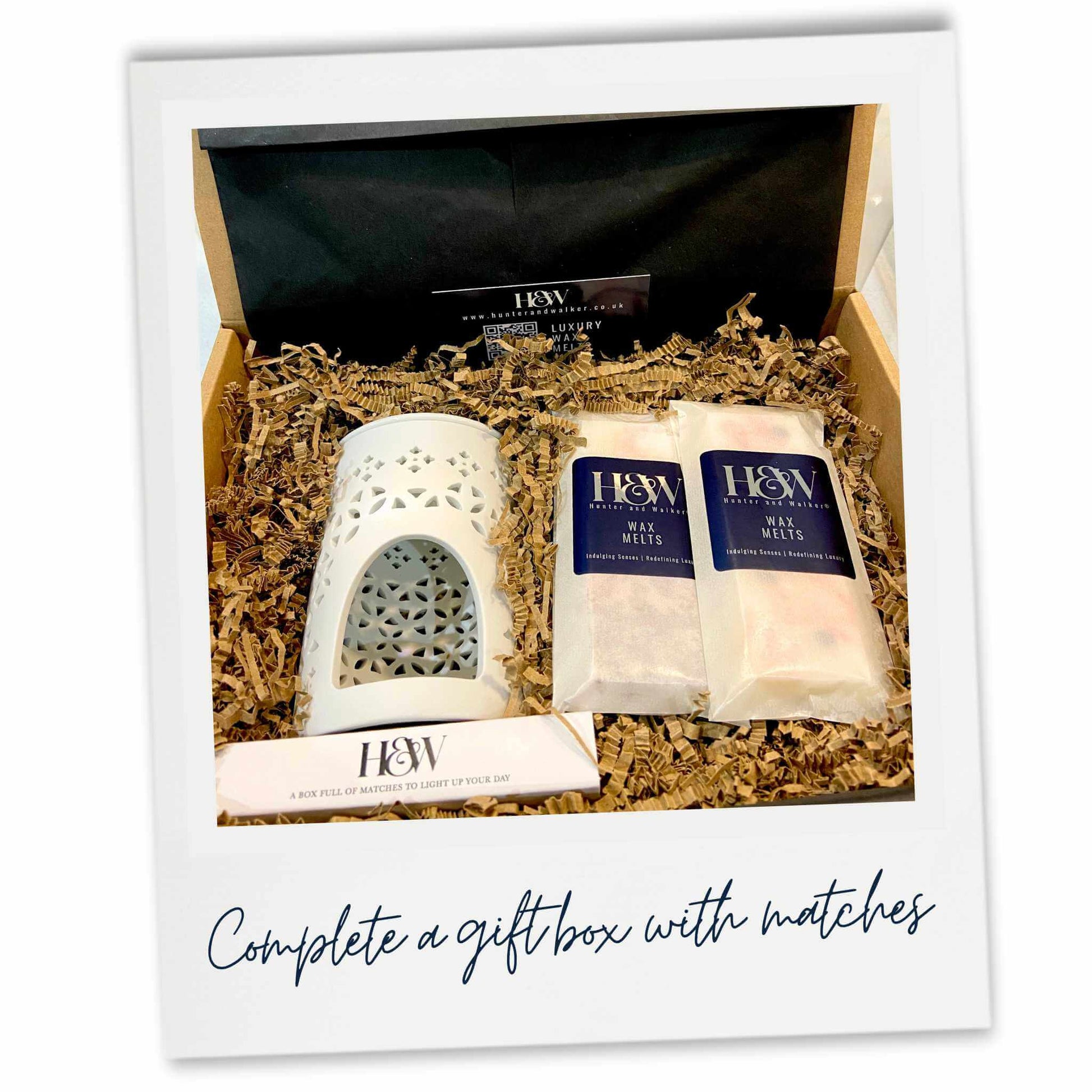 Gift set with a white ceramic warmer, two wax melts and a box of matches.