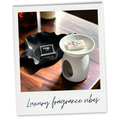 Leather and Oud Wax Melt sample in white wax warmer. Lifestyle image
