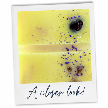 A close up image of Lemon Wax Melt with amethyst crystal and purple mica decoration