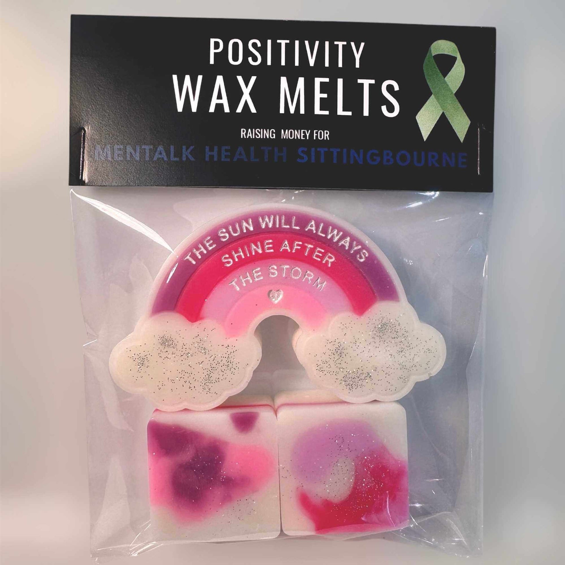 Positivity wax melts set with a pink, purple and white Rainbow design, featuring a green ribbon on a black background.