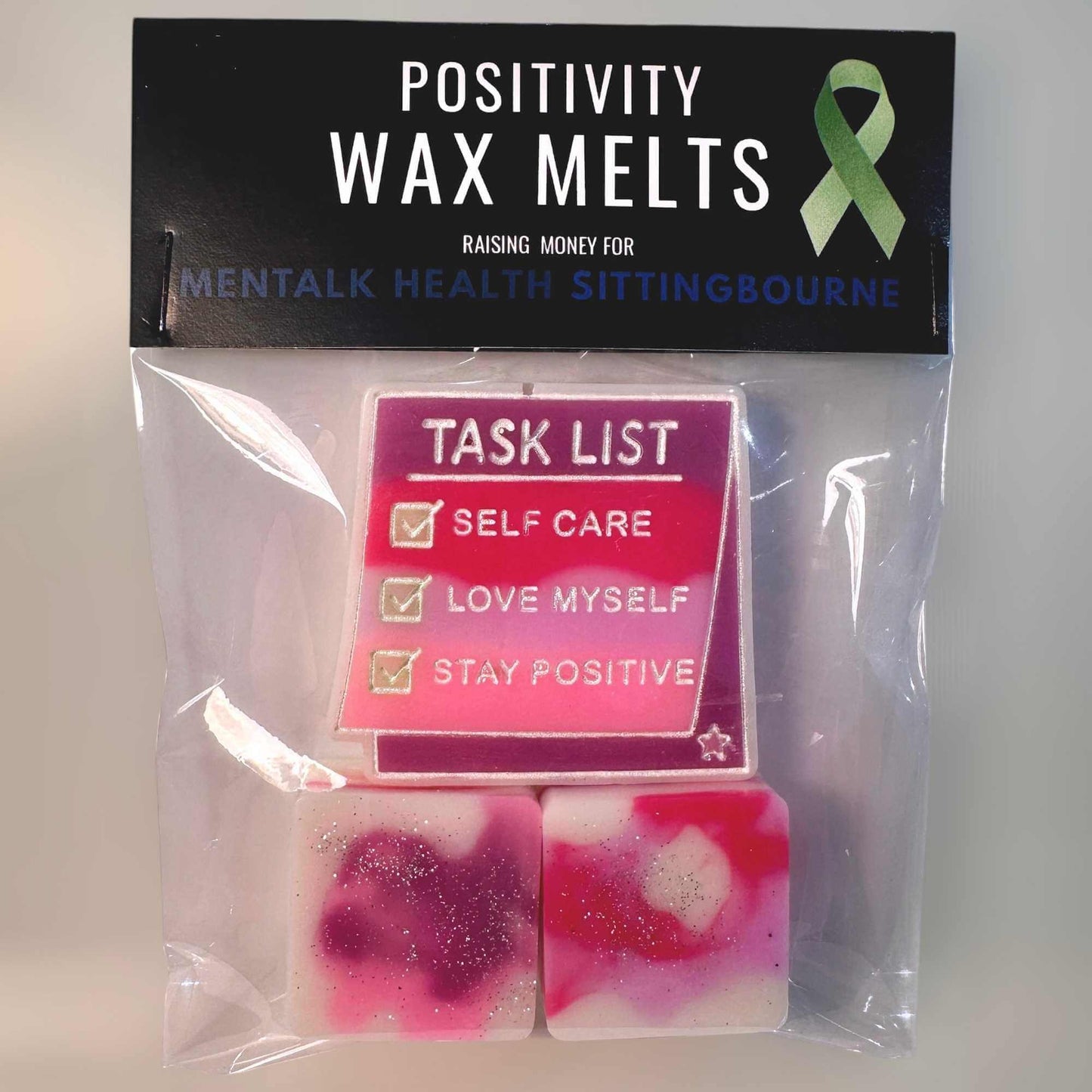 Positivity wax melts set with a pink, purple and white Task List design, featuring a green ribbon on a black background.