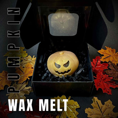 wax melt pumpkin in a black box surrounded by autumn leaves
