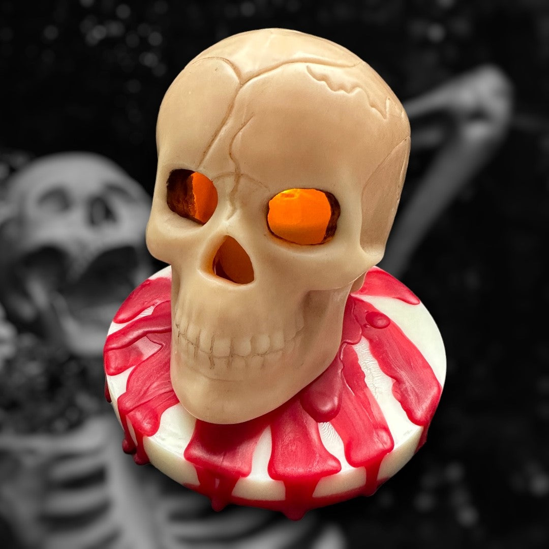 A wax skull sat on a artistic red and white base made to look like dripping blood.