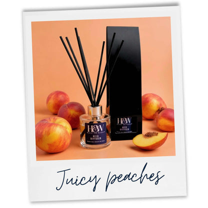 Peach room diffuser with black sticks and peaches on a peach background