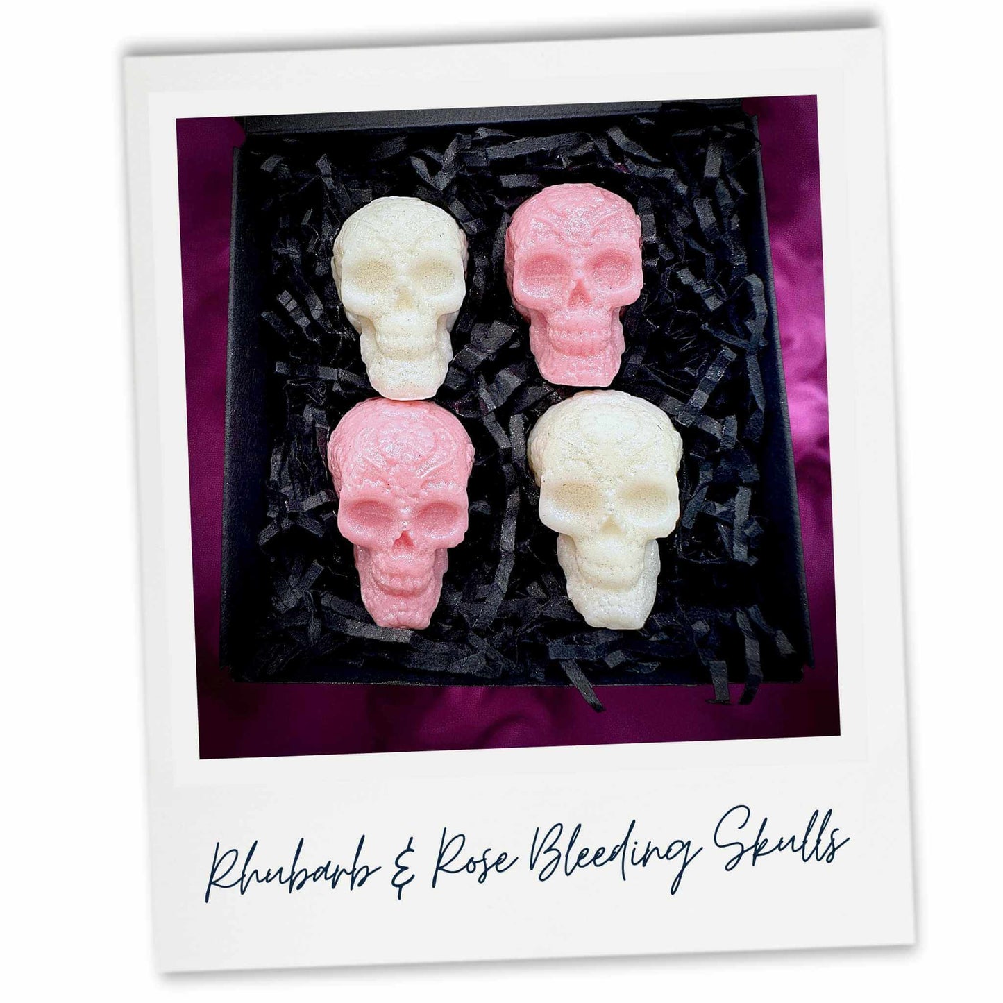 Four skull-shaped pink and white wax melts in a black box with text 'Rhubarb & Rose Bleeding Skulls'.